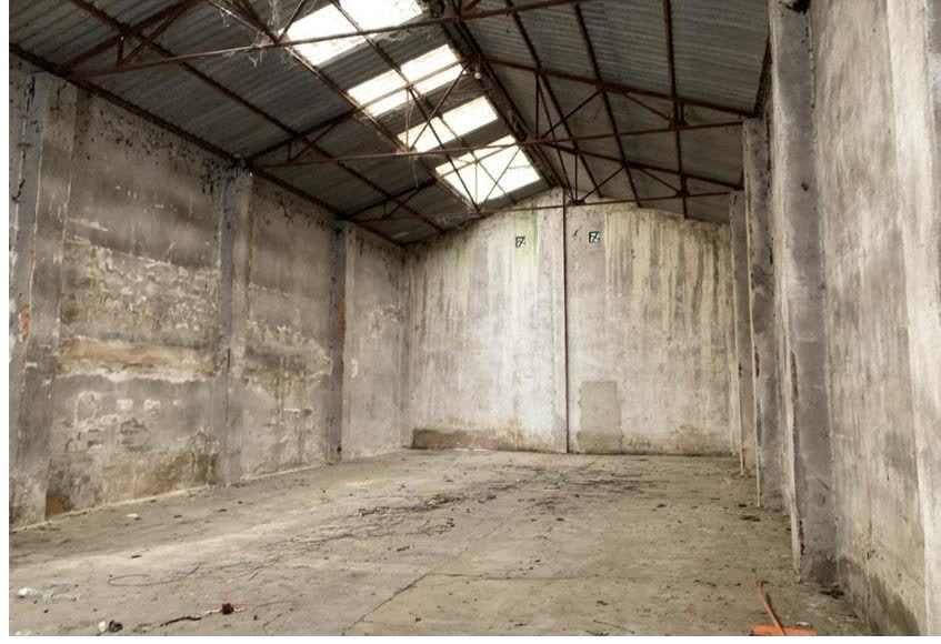 Una nau industrial buida amb teulada de xapa i claraboies